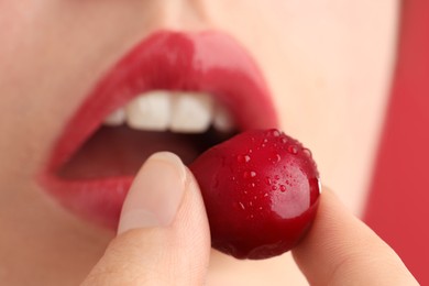 Photo of Woman with beautiful lips makeup and cherry on pink background, closeup