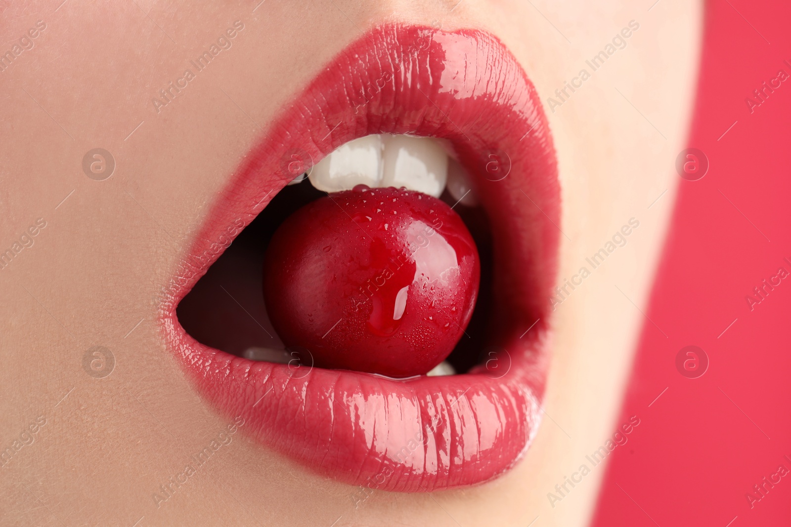 Woman with beautiful lips makeup and cherry on pink background, closeup Photo of Woman with beautiful lips makeup and cherry on pink background, closeup
