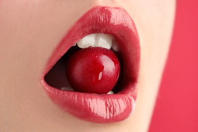 Photo of Woman with beautiful lips makeup and cherry on pink background, closeup