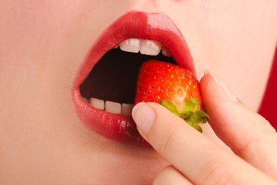Photo of Woman with beautiful lips makeup and strawberry, closeup