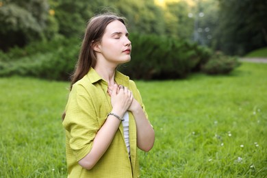 Photo of Woman meditating to heal or restore her aura in nature, space for text
