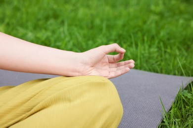 Photo of Woman meditating to heal or restore her aura in park, closeup