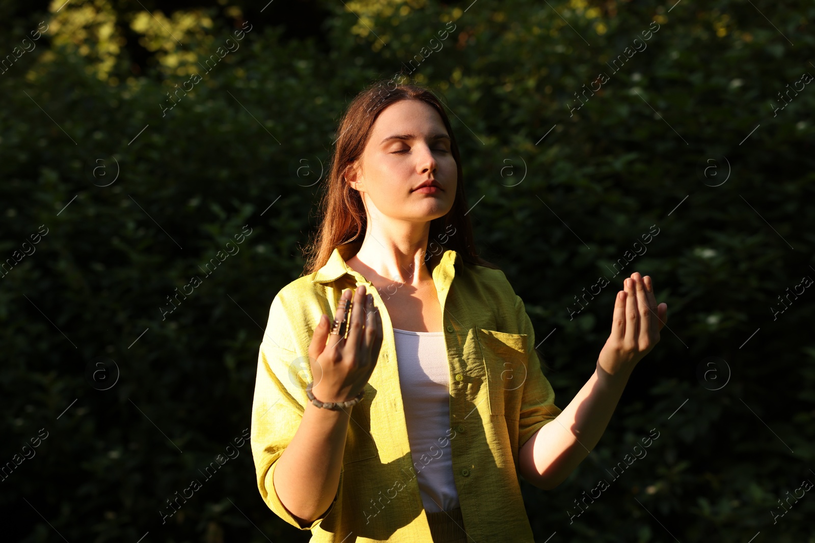 Photo of Woman meditating to heal or restore her aura in nature