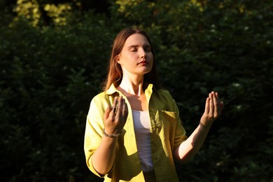 Photo of Woman meditating to heal or restore her aura in nature