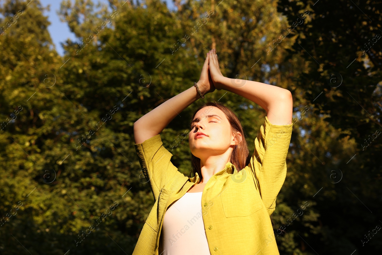Photo of Woman meditating to heal or restore her aura in nature