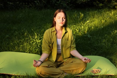 Photo of Woman meditating with crystals to heal or restore her aura outdoors