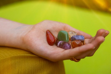 Photo of Woman meditating with crystals to heal or restore her aura outdoors, closeup