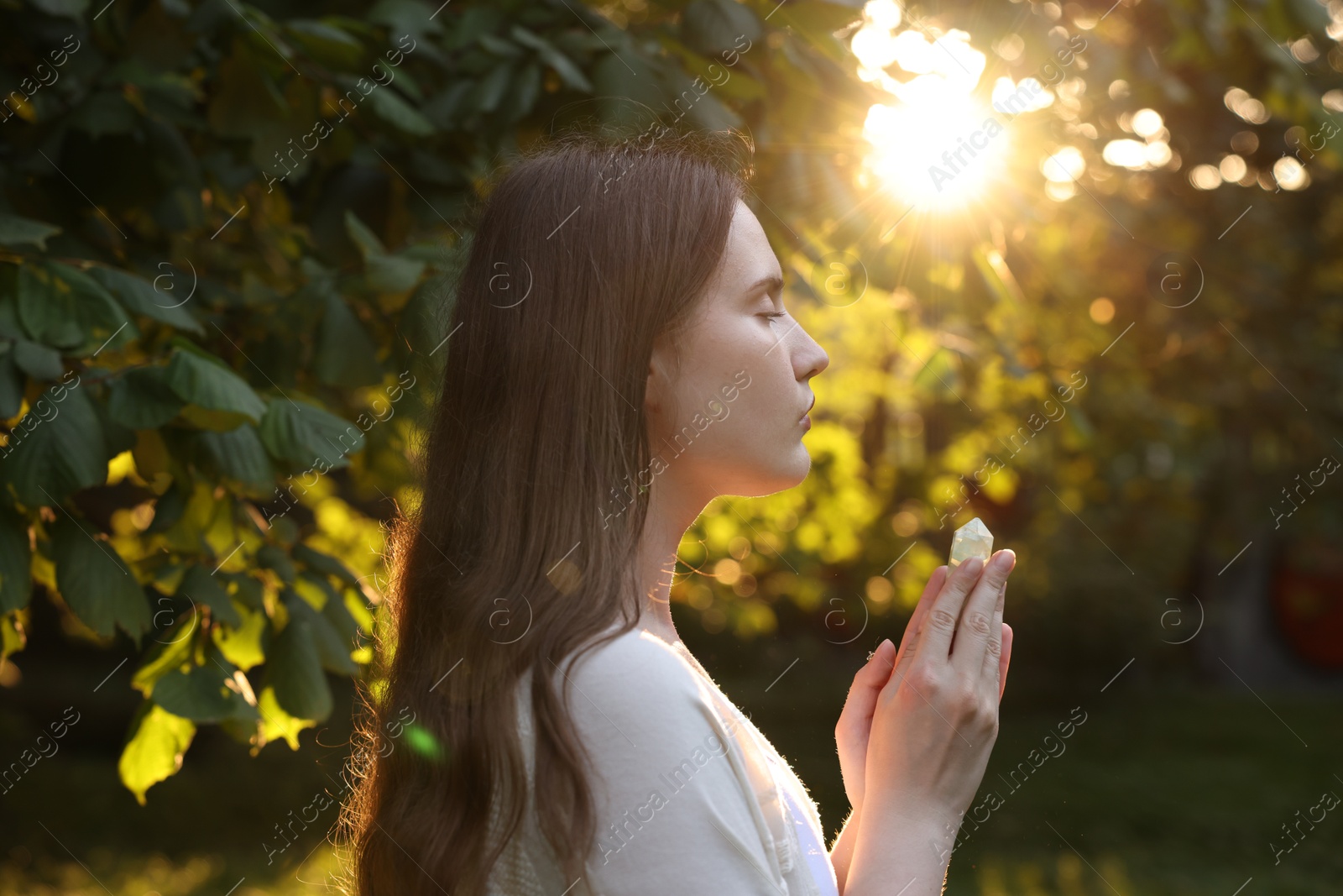 Woman meditating with crystal to heal or restore her aura outdoors Photo of Woman meditating with crystal to heal or restore her aura outdoors