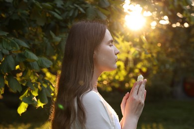 Photo of Woman meditating with crystal to heal or restore her aura outdoors