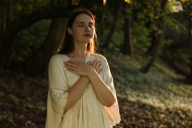 Photo of Woman meditating to heal or restore her aura in nature