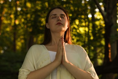 Photo of Woman meditating to heal or restore her aura in nature