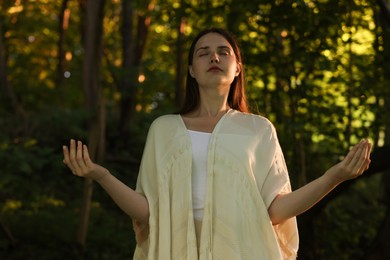 Photo of Woman meditating to heal or restore her aura in nature