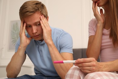 Photo of Worried couple with pregnancy test at home