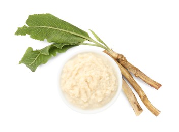 Photo of Tasty horseradish sauce in bowl, roots and leaves isolated on white, top view