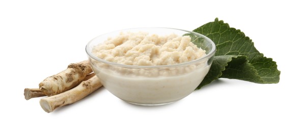 Photo of Tasty horseradish sauce in bowl, roots and leaf isolated on white