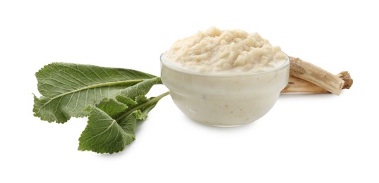 Photo of Tasty horseradish sauce in bowl, roots and leaves isolated on white