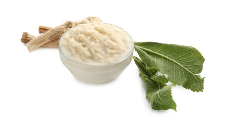 Photo of Tasty horseradish sauce in bowl, roots and leaves isolated on white