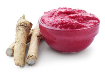 Photo of Tasty horseradish sauce with beetroot in bowl and roots isolated on white
