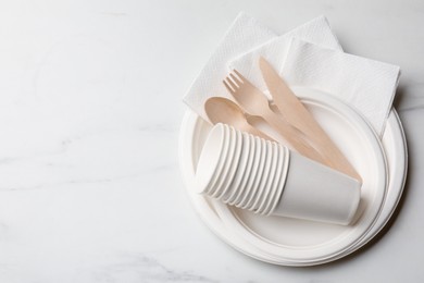 Photo of Set of disposable tableware on white background, top view. Space for text
