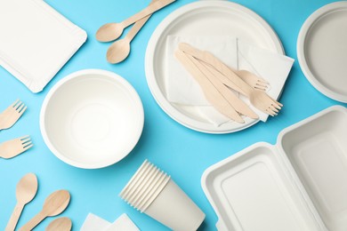 Photo of Set of disposable tableware on light blue background, flat lay