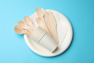 Photo of Set of disposable tableware on light blue background, top view