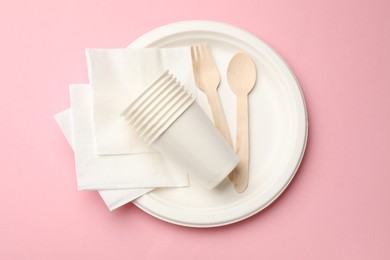 Photo of Set of disposable tableware on pink background, top view