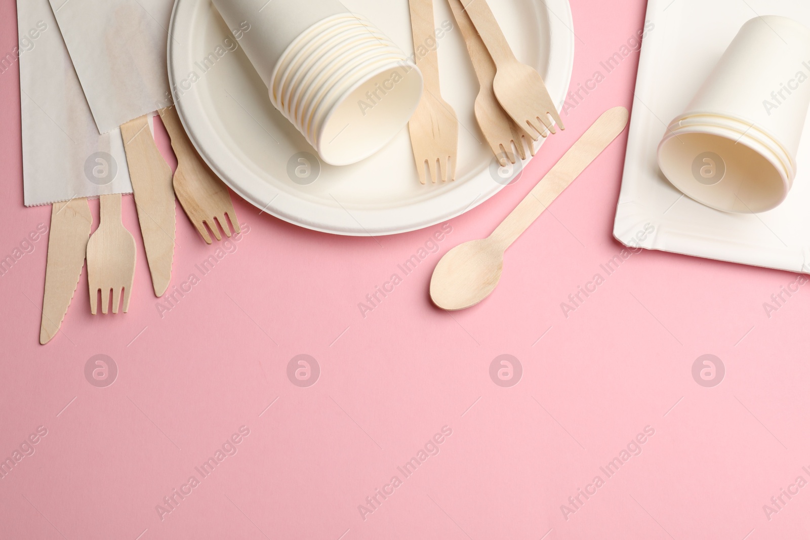 Set of disposable tableware on pink background, flat lay. Space for text Photo of Set of disposable tableware on pink background, flat lay. Space for text