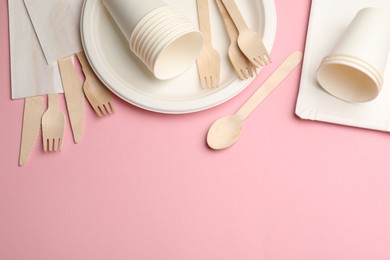 Photo of Set of disposable tableware on pink background, flat lay. Space for text