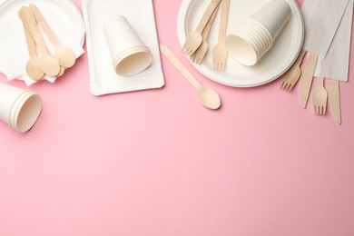 Photo of Set of disposable tableware on pink background, flat lay. Space for text
