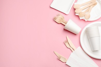 Photo of Set of disposable tableware on pink background, flat lay. Space for text