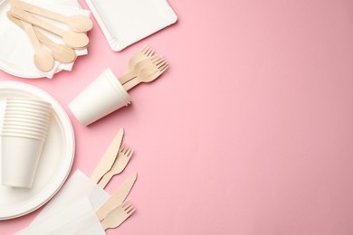 Photo of Set of disposable tableware on pink background, flat lay. Space for text