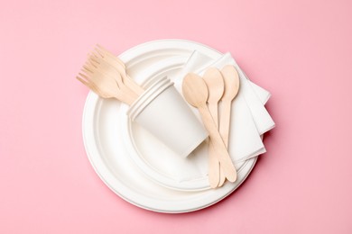 Photo of Set of disposable tableware on pink background, top view
