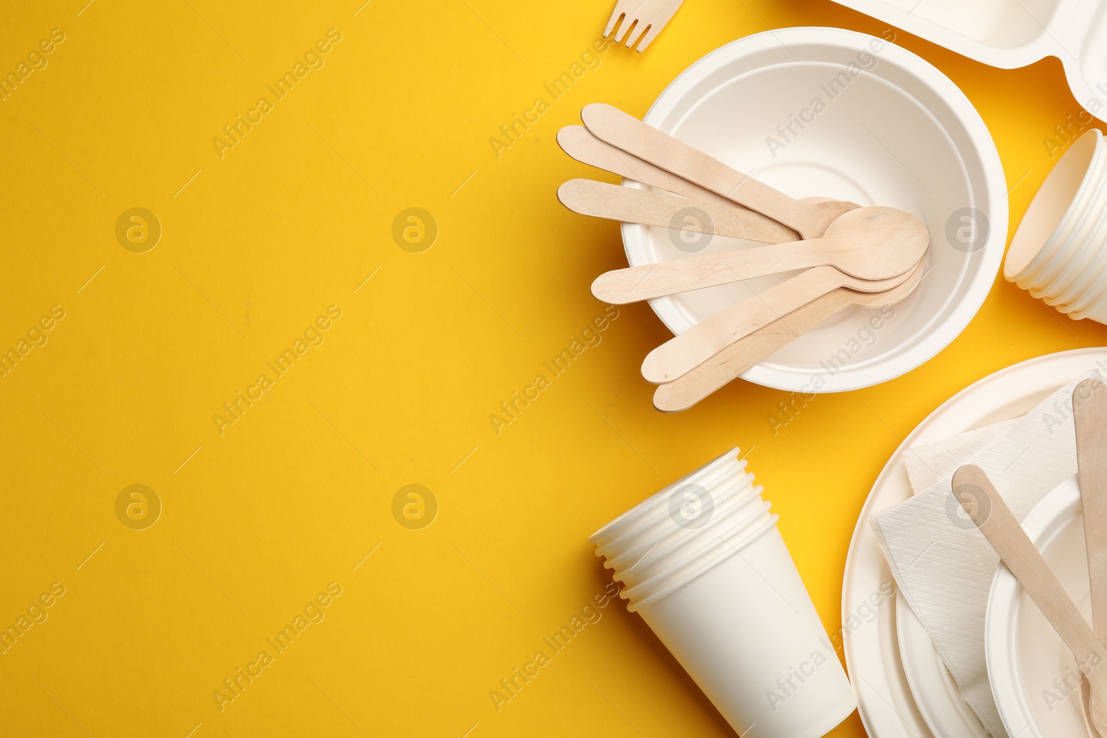 Set of disposable tableware on yellow background, flat lay. Space for text Photo of Set of disposable tableware on yellow background, flat lay. Space for text