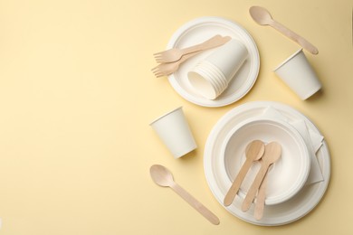 Photo of Set of disposable tableware on beige background, flat lay. Space for text