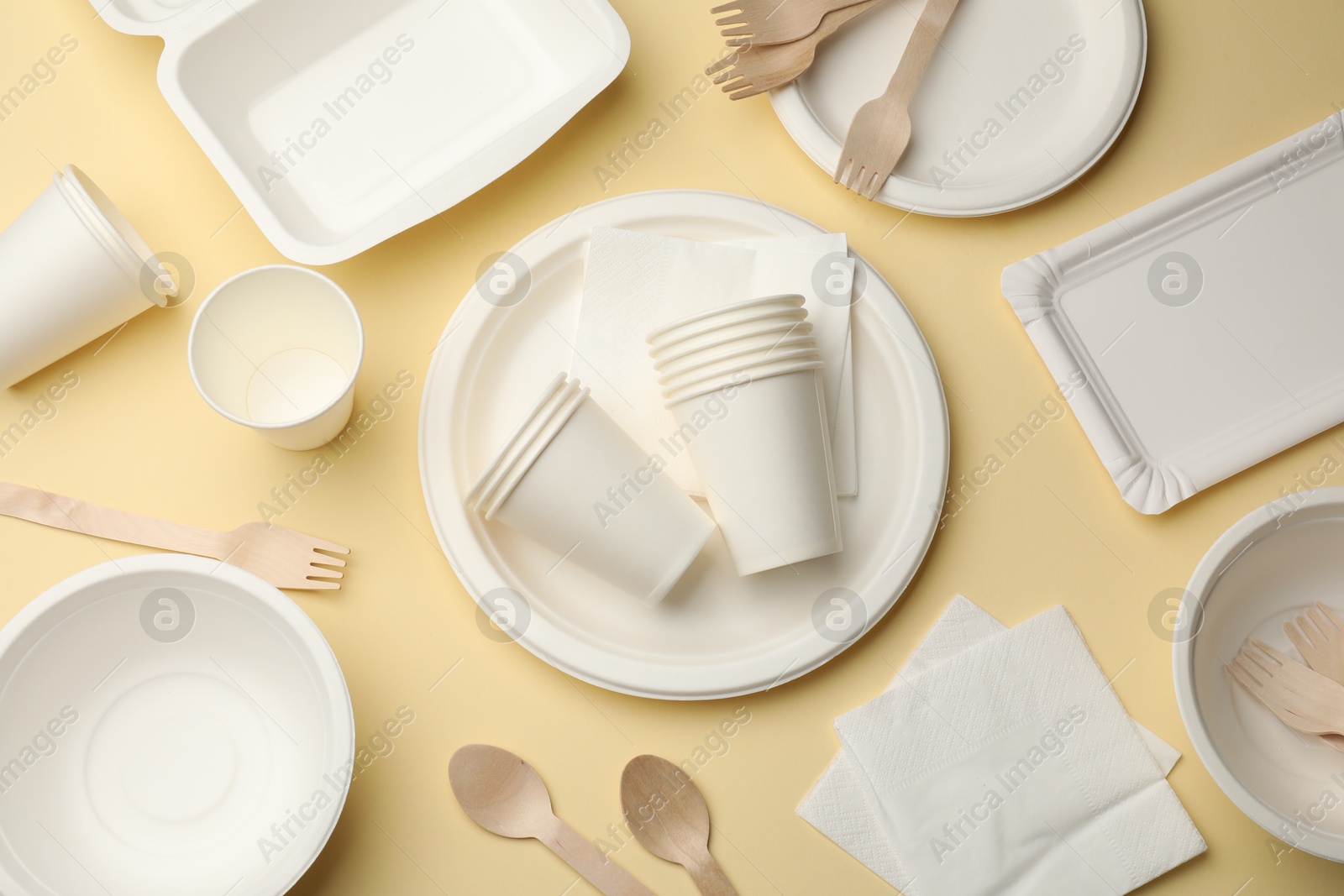 Set of disposable tableware on beige background, flat lay Photo of Set of disposable tableware on beige background, flat lay