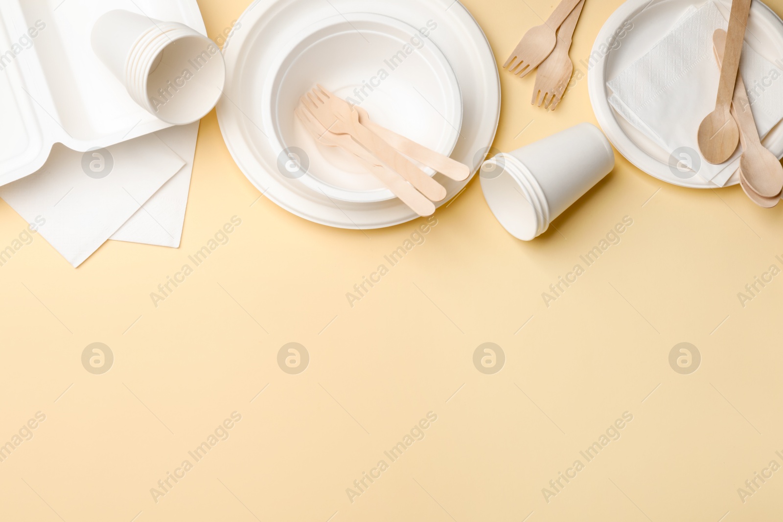 Set of disposable tableware on beige background, flat lay. Space for text Photo of Set of disposable tableware on beige background, flat lay. Space for text