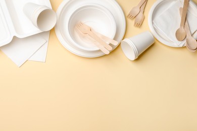 Photo of Set of disposable tableware on beige background, flat lay. Space for text