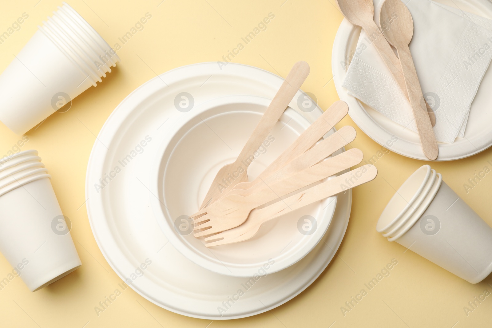 Set of disposable tableware on beige background, flat lay Photo of Set of disposable tableware on beige background, flat lay