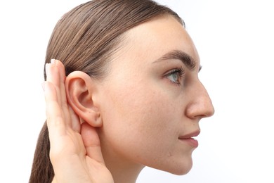 Photo of Sound. Woman showing hand to ear gesture on white background, closeup