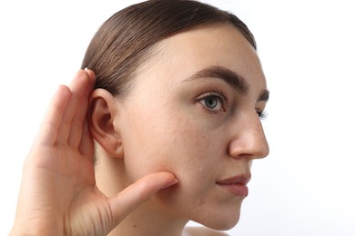 Photo of Sound. Woman showing hand to ear gesture on white background, closeup