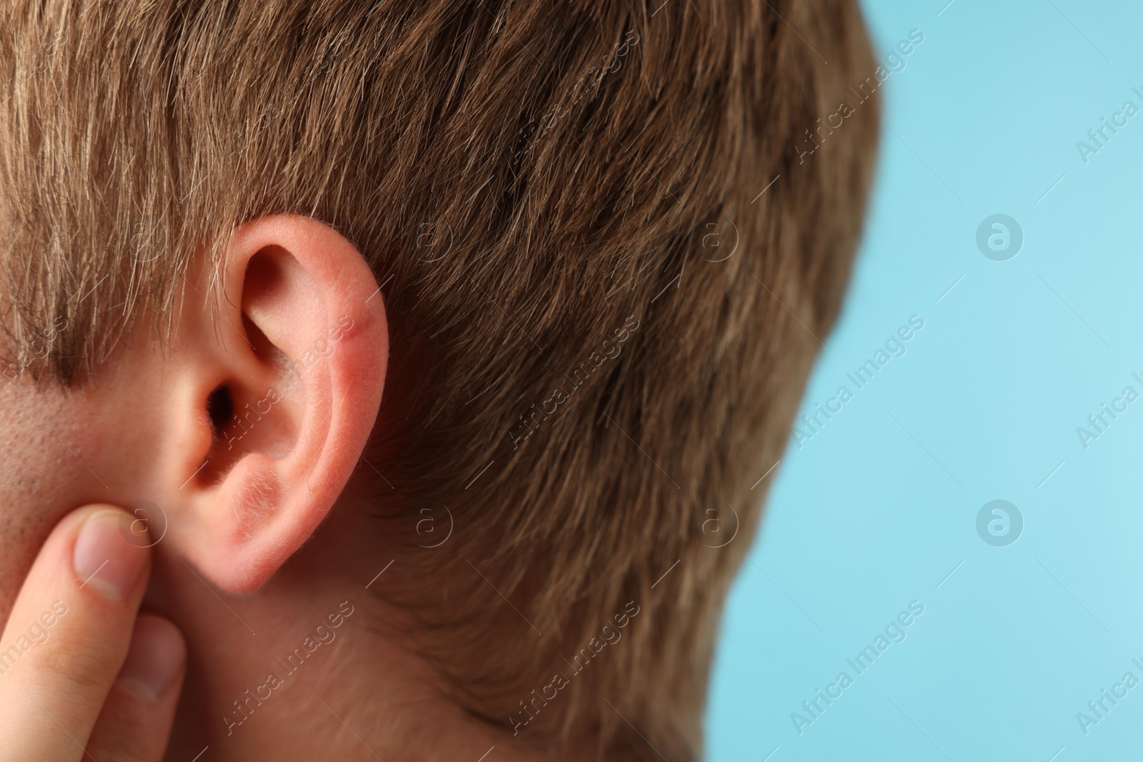 Photo of Sound. Man on light blue background, closeup. Space for text