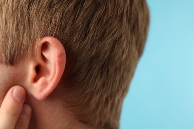 Photo of Sound. Man on light blue background, closeup. Space for text