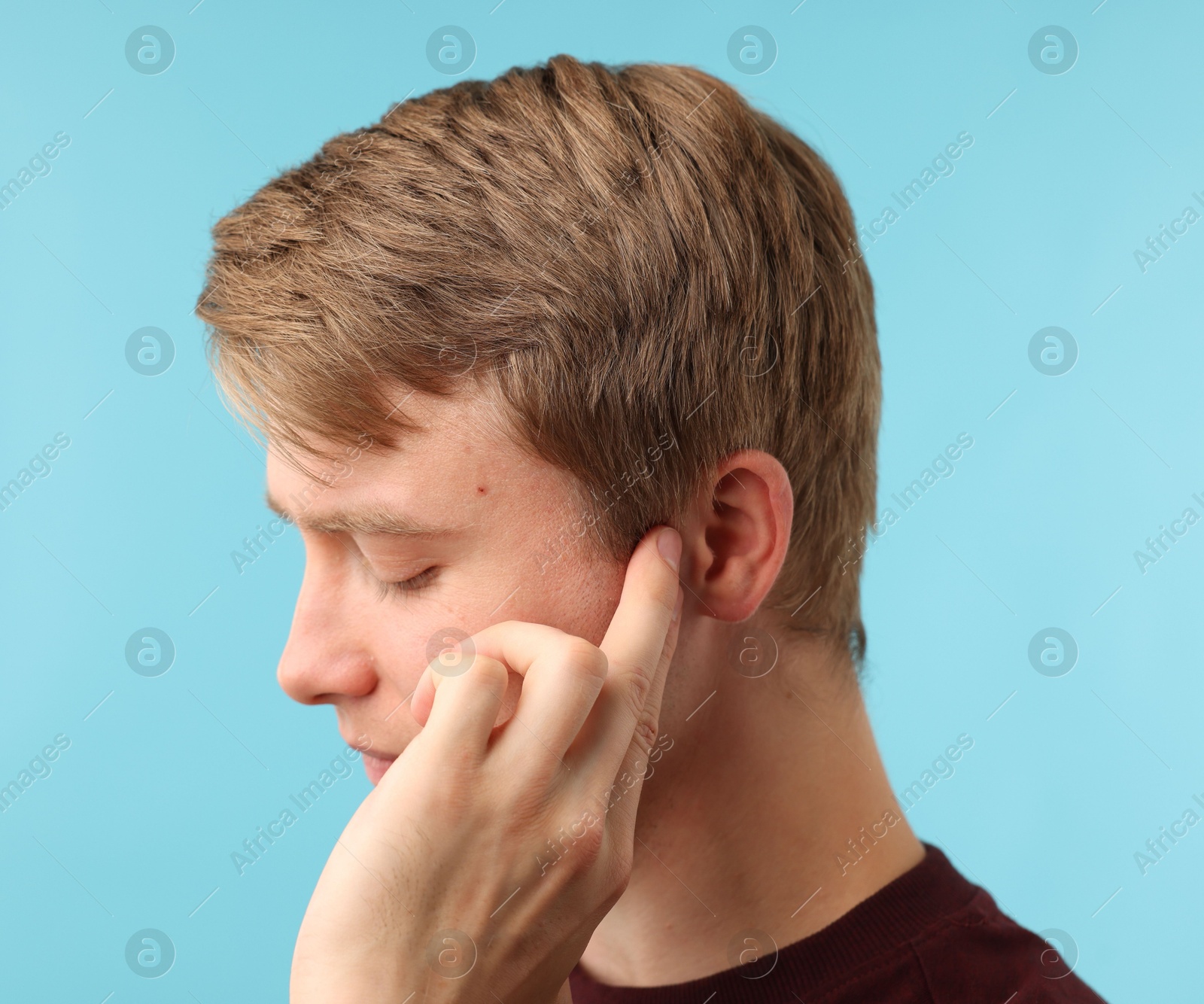 Photo of Sound. Man with hearing problem on light blue background