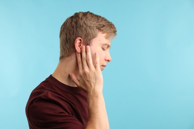 Photo of Sound. Man with hearing problem on light blue background, space for text