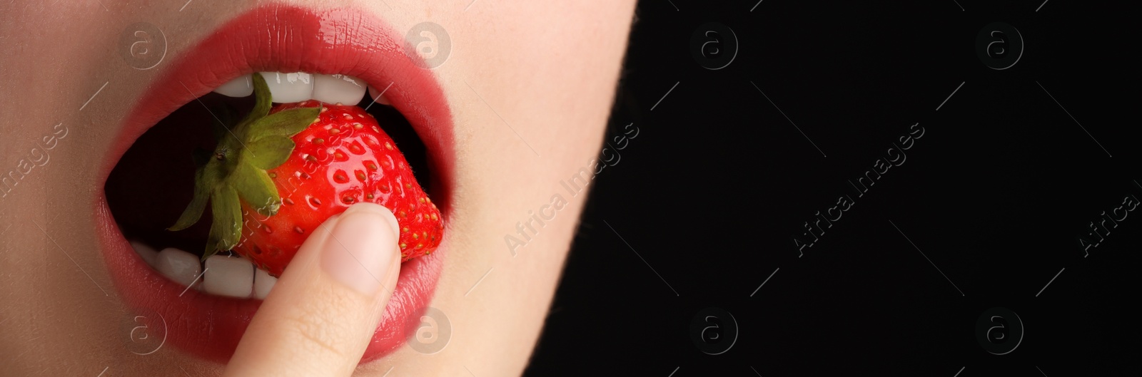 Woman with beautiful lips makeup and strawberry on black background, closeup. Space for text Photo of Woman with beautiful lips makeup and strawberry on black background, closeup. Space for text