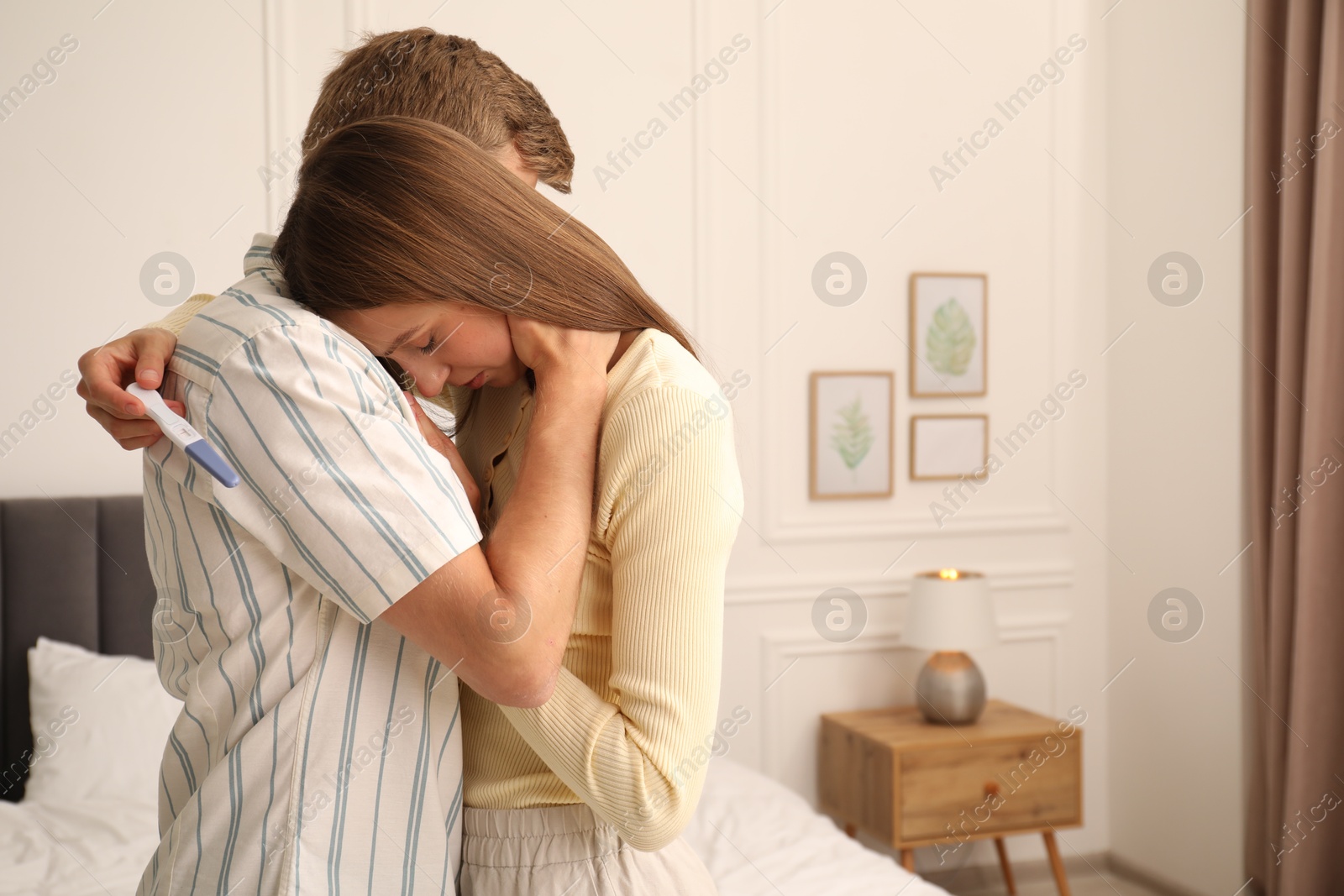 Photo of Worried couple with pregnancy test in bedroom