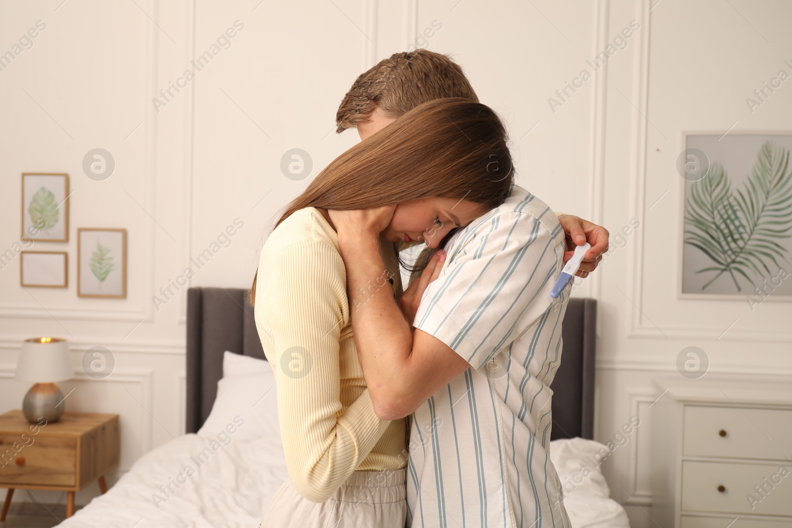 Photo of Worried couple with pregnancy test in bedroom
