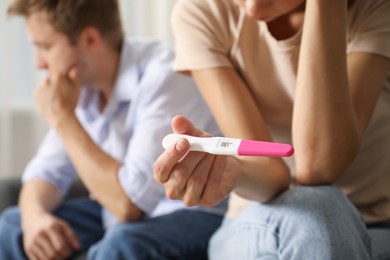 Photo of Couple with positive pregnancy test at home, selective focus