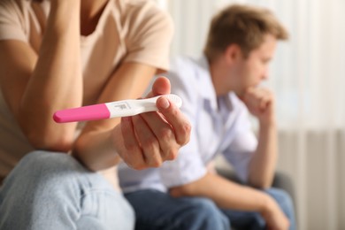Photo of Couple with pregnancy test at home, selective focus