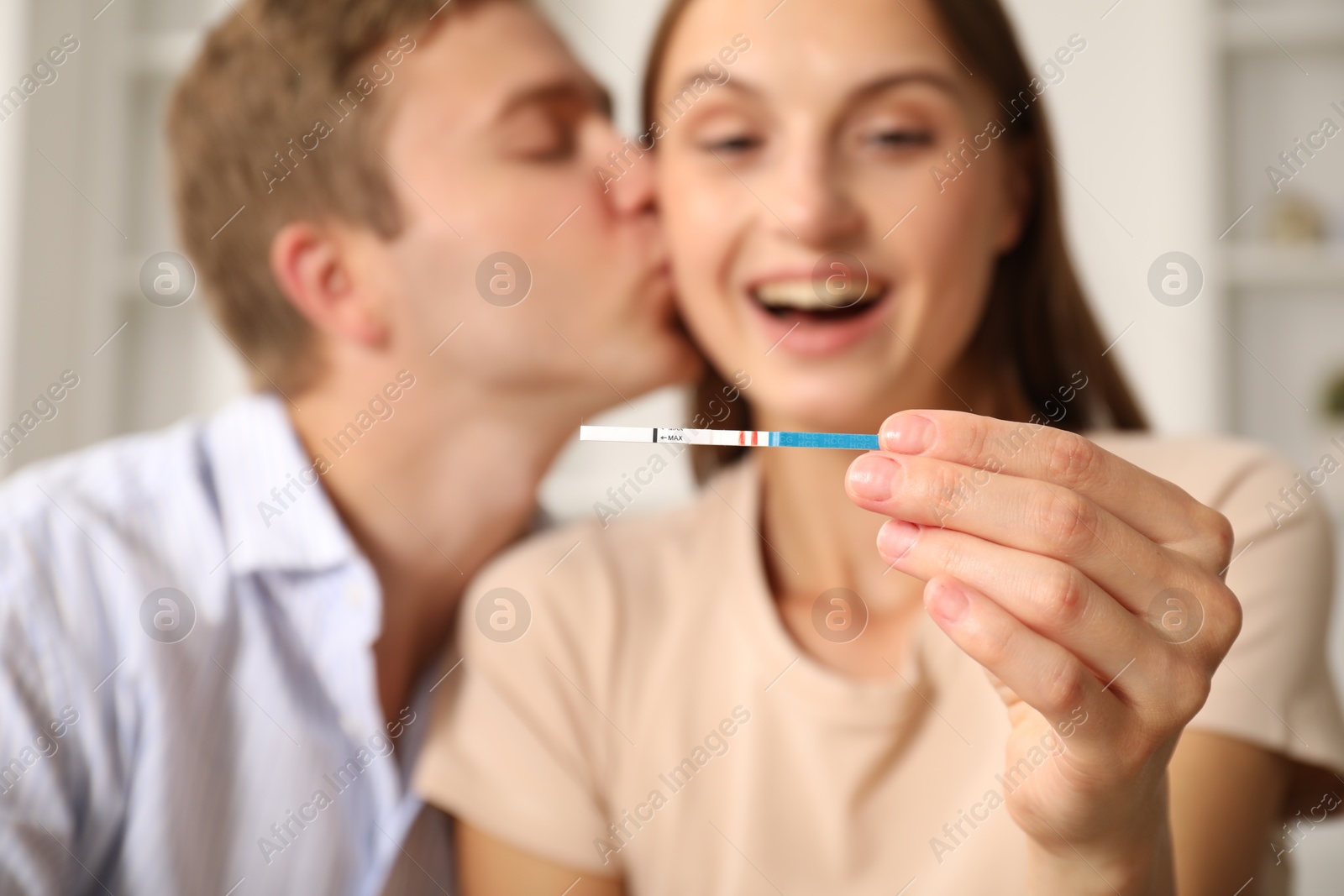 Happy couple with pregnancy test at home, selective focus Photo of Happy couple with pregnancy test at home, selective focus